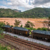 Freight train transporting ore passing in front of the contamina