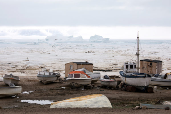 Boats and the frozen harbor of Qaanaaq, Greenland photographed by Anna Filipova.