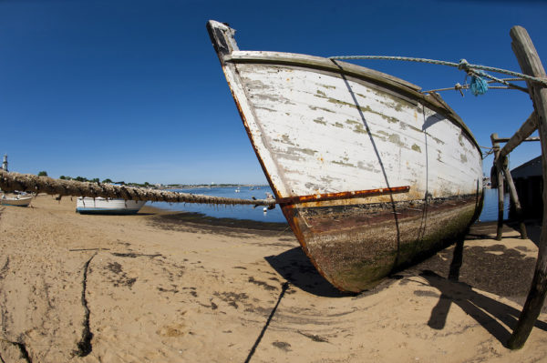 An abandoned wooden fishing boat is seen on a beach on Cape Cod.